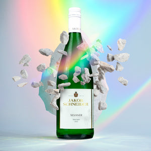 Eine Weinflasche Jakob Schneider, Silvaner, Trocken, 1 Liter-Flasche, mehre weiße Steinchen fliegen um die Flasche herum.