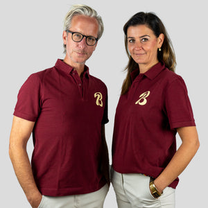 Ein Mann und eine Frau tragen ein rotes Poloshirt mit einem Bott1e-Logo.