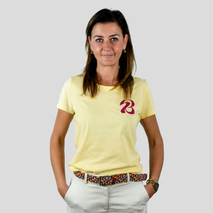Eine Frau trägt ein gelbes T-Shirt mit einem Bott1e-Logo, Vorderseite.